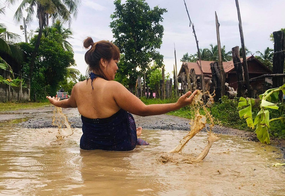 ชาวบ้านสุดทน ถ่ายคลิป นุ่งกระโจมอกอาบน้ำ กลางถนนชำรุดมานานกว่า 10 ปี ไร้เหลียวแล โพสต์ประชด