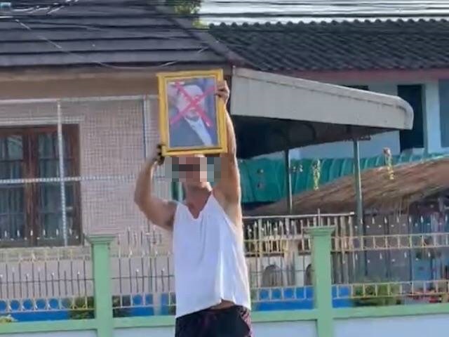 ฝรั่งเยอรมัน ถือรูป " บิ๊กป้อม" ขีดกากบาทตรงหน้าสีแดง ชูกลางสี่แยกระยอง 