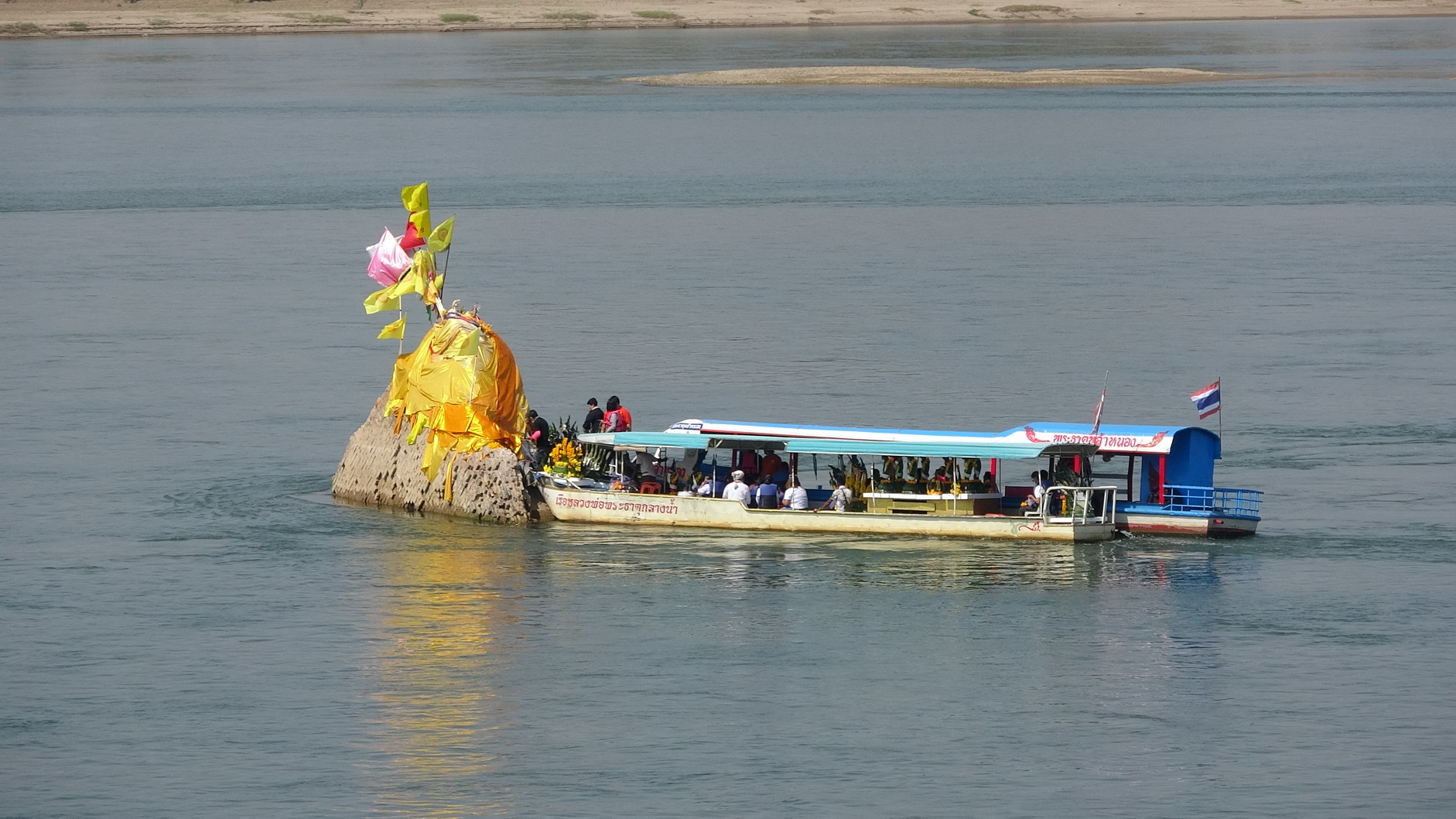 พุทธศาสนิกชนไทย-นทท.ต่อคิวสักการะขอพร ห่มผ้าพระธาตุกลางน้ำ จุดที่มีพิธีลอยอังคารเถ้าอัฐิหลวงพ่อคูณ