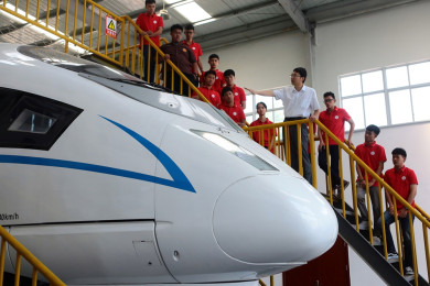 นักศึกษาต่างชาติ (ใส่เสื้อสีแดง) จากลูปันเวิร์คช็อปประเทศไทย เยี่ยมชมฐานฝึกรถไฟความเร็วสูงของวิทยาลัย